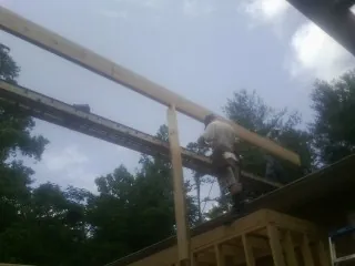 Carpenter setting a ridge beam over a new addition frame — Ice Dam Removal by Roofing Brothers in Oakland Mills
