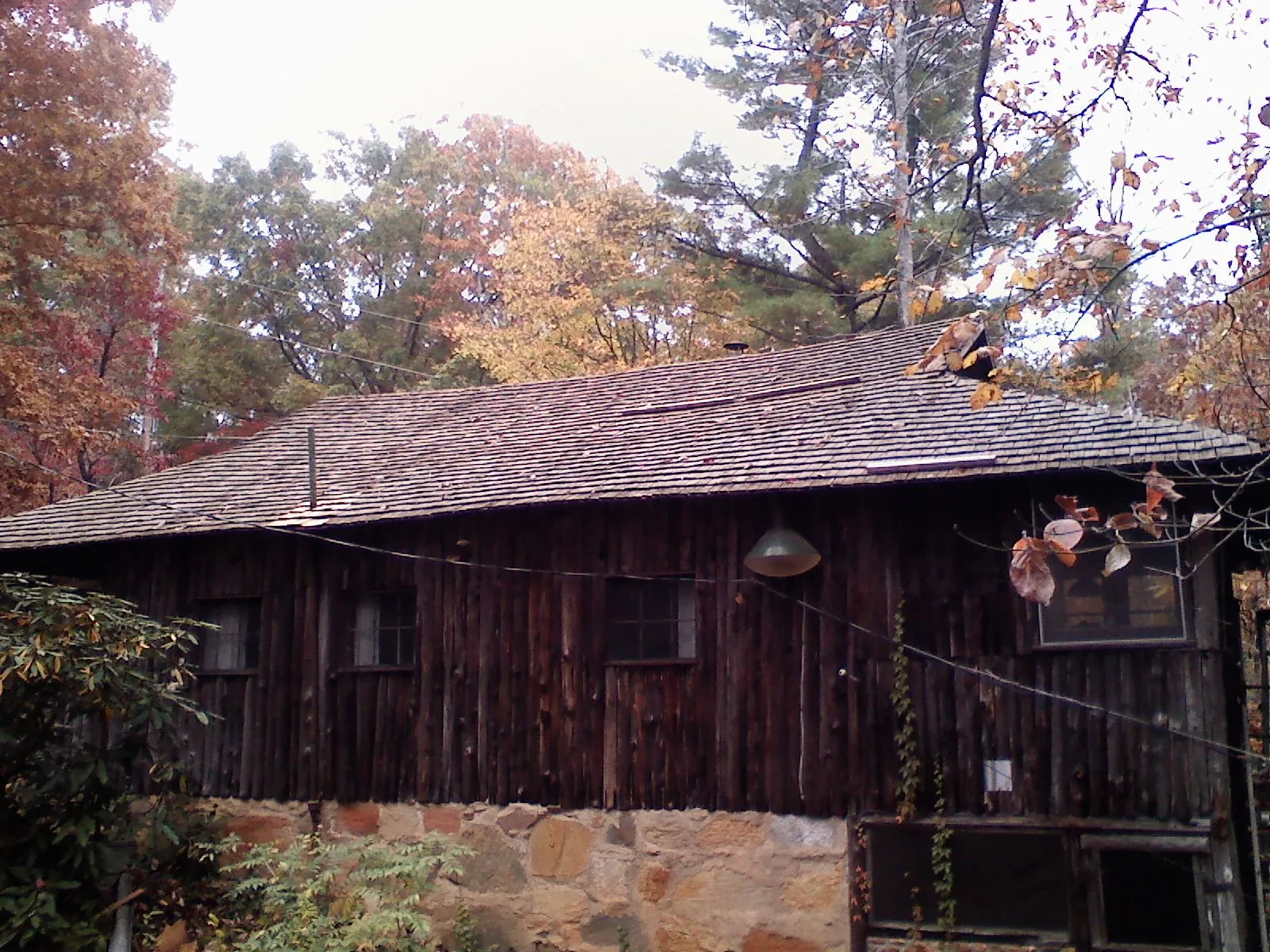 Weathered wood shake roof on a rustic board sided cabin in Oakland Mills