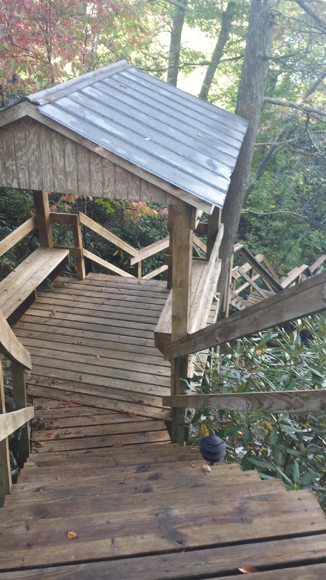 Metal roofed shelter over wooden steps on a wooded walkway — Skylight Repair & Installation work by our crew in Oakland Mills