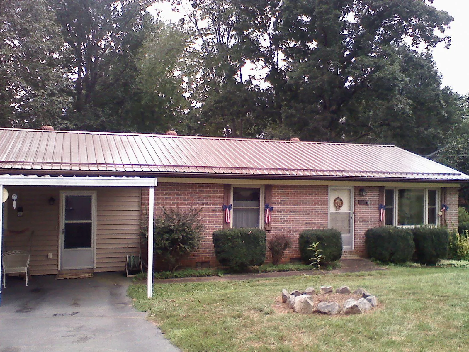 Bronze metal roof and carport on a brick ranch home — Roof Repair work by our crew in Oakland Mills